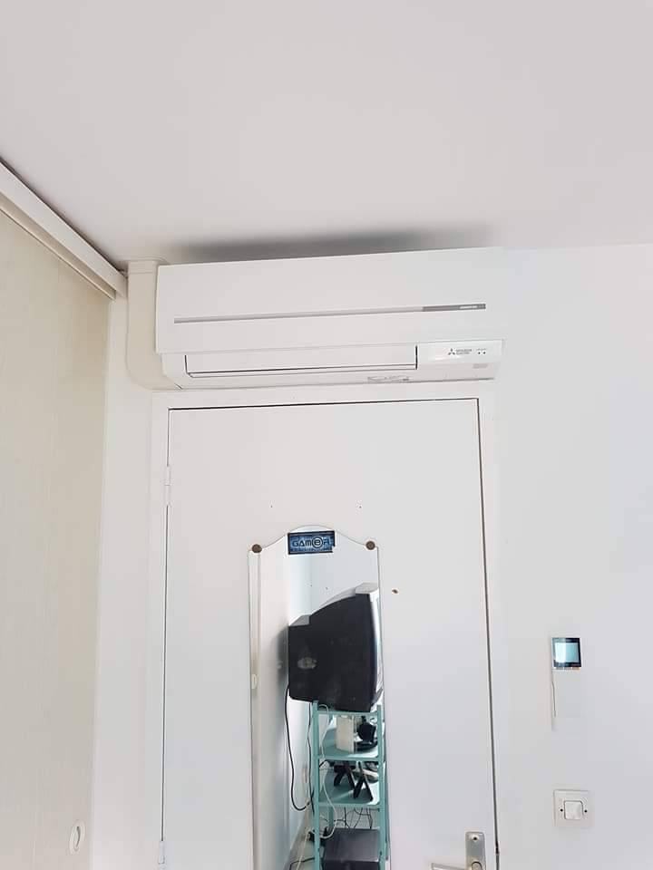 Climatisation Mitsubishi Electric au dessus d'une porte de maison à Melun